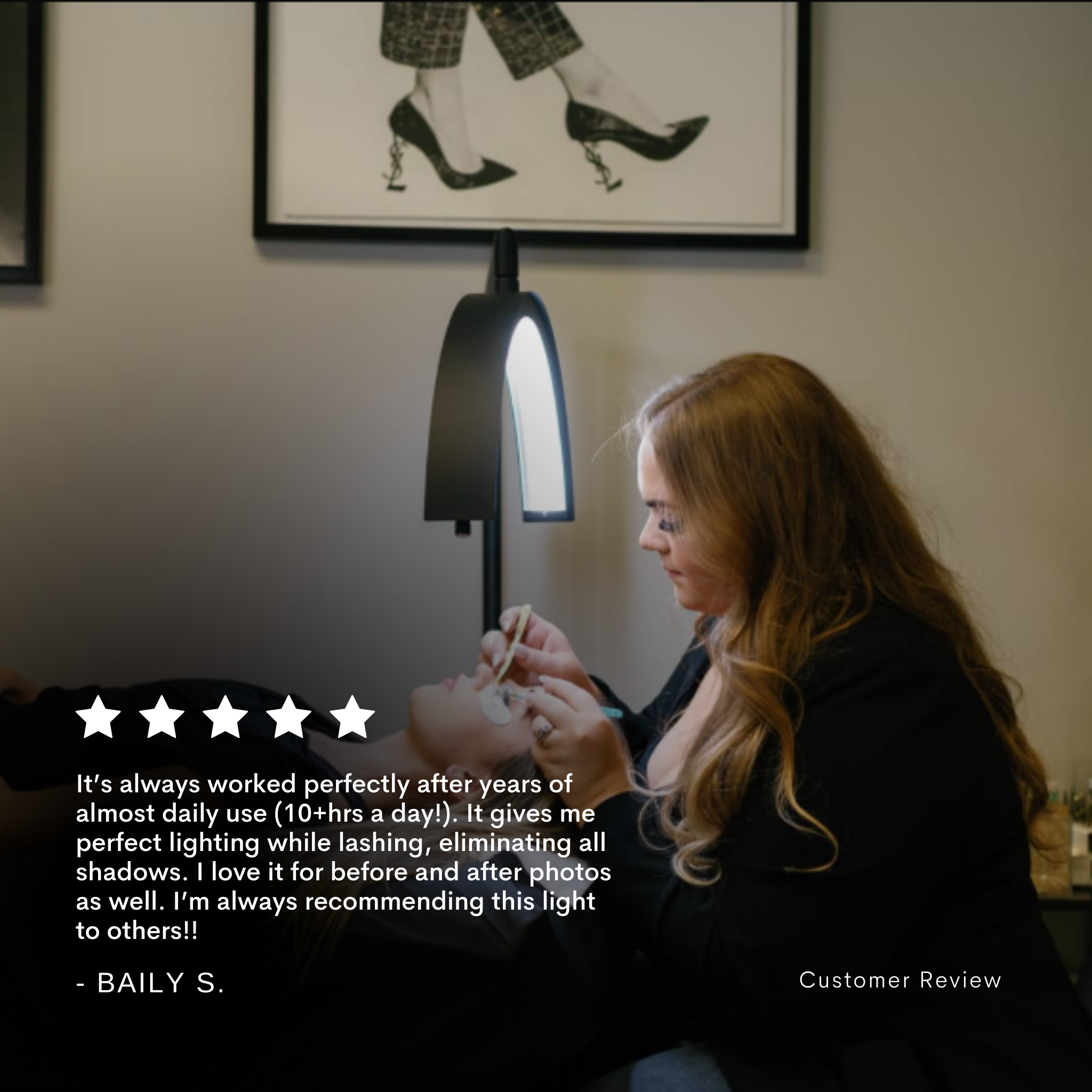 Woman using a lamp with a framed picture of feet in high heels on the wall.