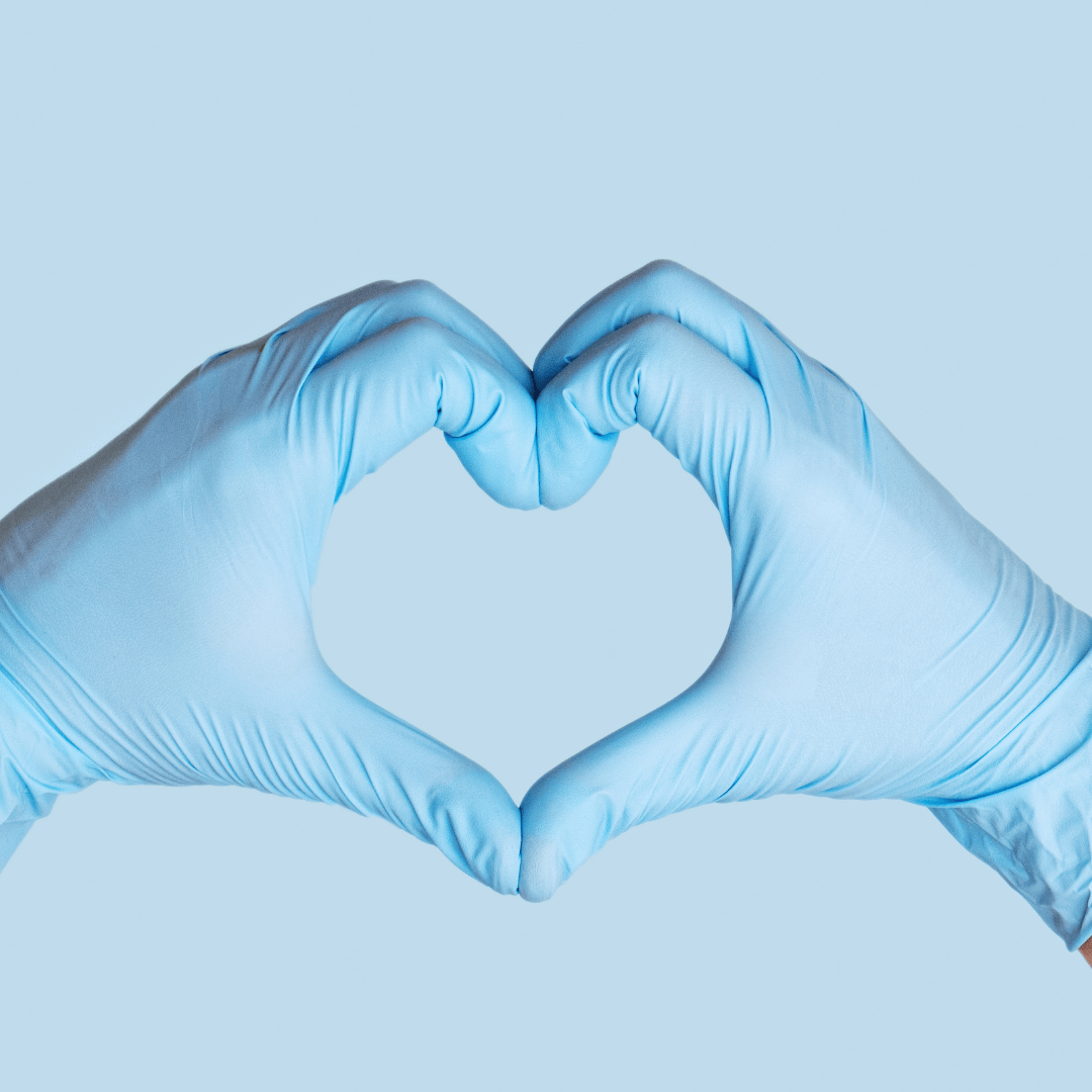 Clean gloved hands forming a heart, symbolizing care and support.