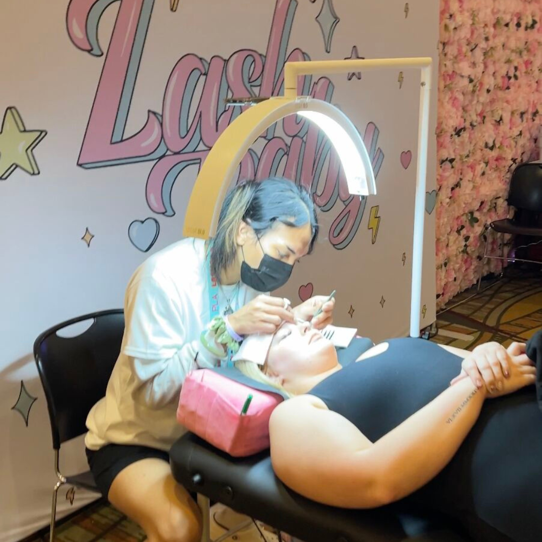 Lash Baby using CosmoGlo eyelash extension lights at LASHCON - the biggest lash event.