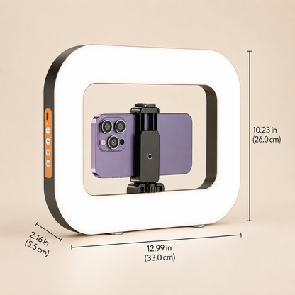 A square LED ring light with a white illuminated frame and black outer trim, shown with overlaid dimension lines and measurements on a beige background. A purple smartphone is mounted inside the ring on a small black stand.