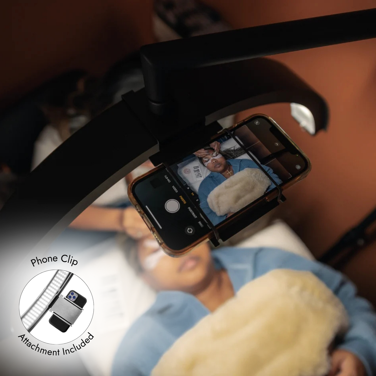 Person using a smartphone with a phone clip attachment in a car.